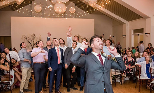 Groom Tossing Garter to Guests